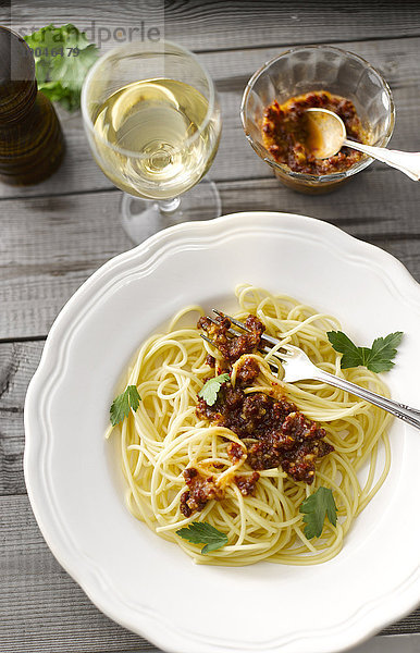 Spaghetti mit Tomatenpesto und einem Glas Weißwein