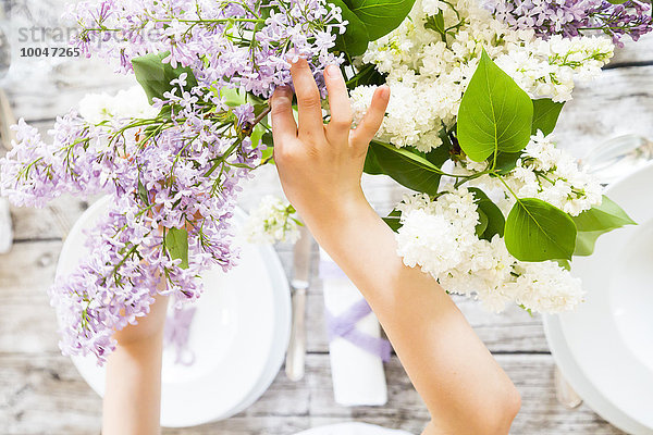 Mädchen beim Tischdecken  lila Blumen