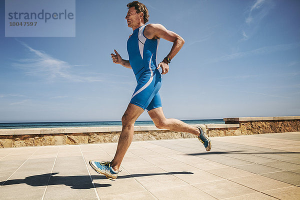 Spanien  Mallorca  Sa Coma  Triathlet entlang der Strandpromenade