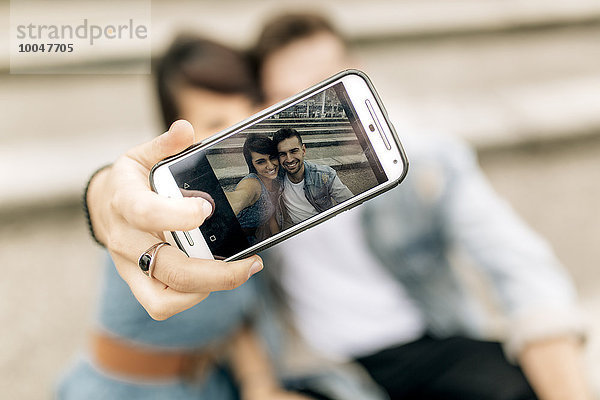 Spanien  Gijon  junges verliebtes Paar mit Smartphone