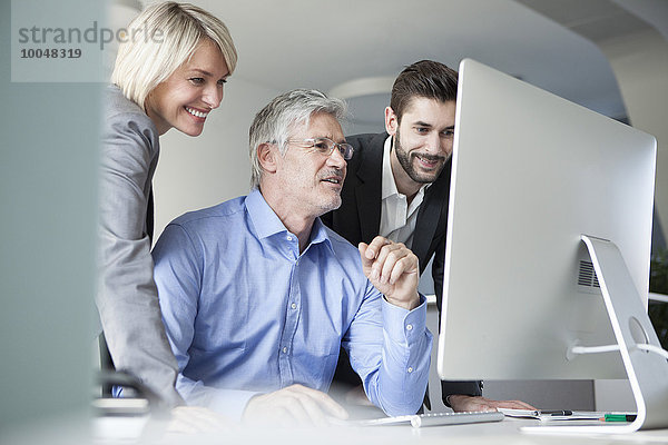 Geschäftsleute diskutieren über die Arbeit am Computer