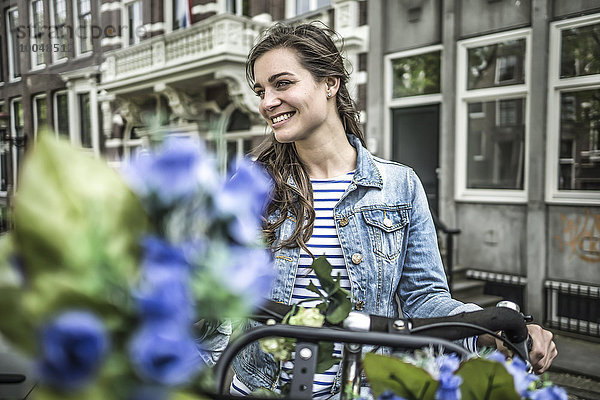 Niederlande  Amsterdam  lächelnde Frau mit Fahrrad