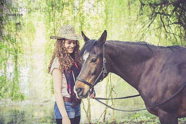 Lächelnde junge Frau mit arabischem Pferd