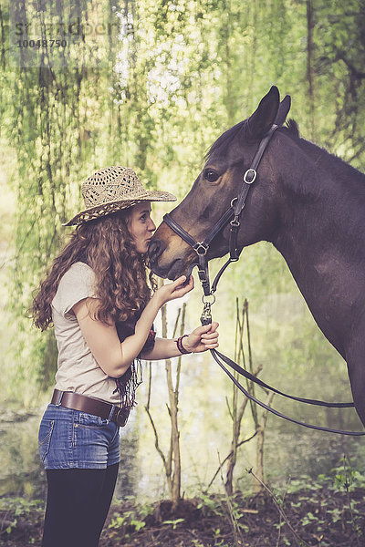 Junge Frau küsst arabisches Pferd