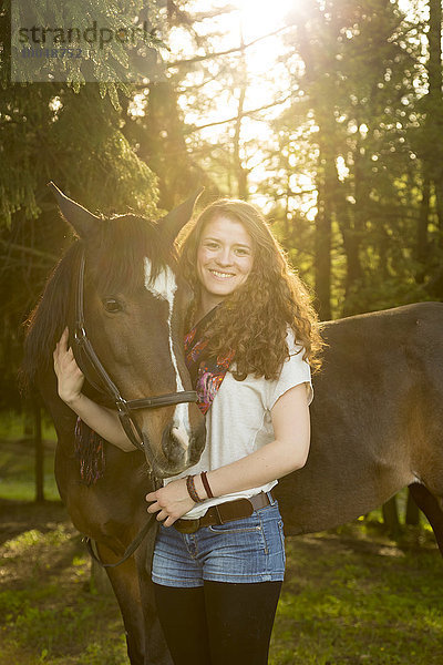 Lächelnde junge Frau mit arabischem Pferd
