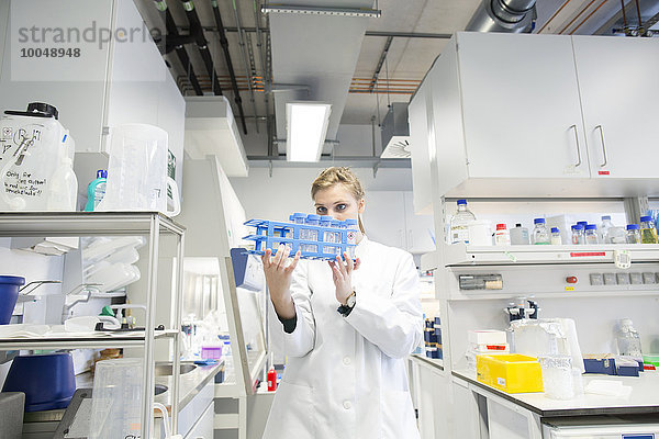 Junge Wissenschaftlerin im biologischen Labor bei der Probenkontrolle