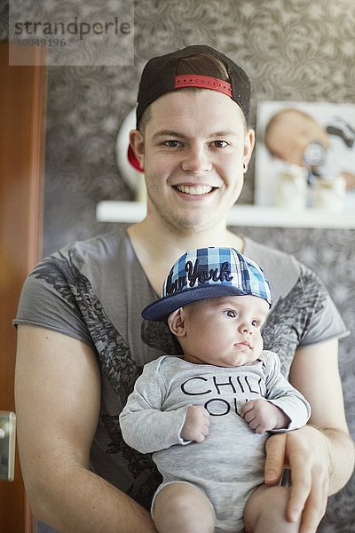 Porträt des lächelnden jungen Vaters mit Baby