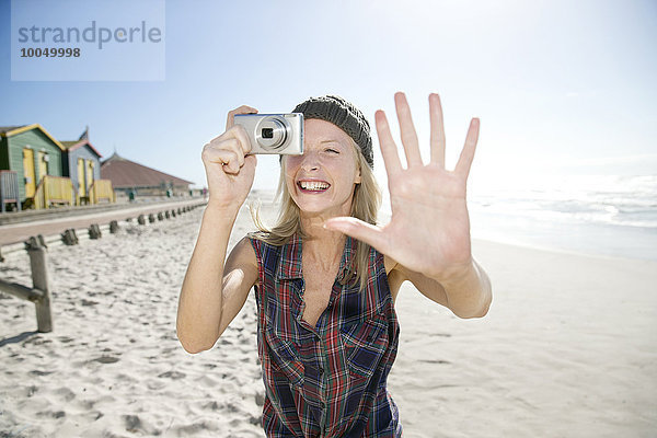 Junge Frau beim Fotografieren am Strand
