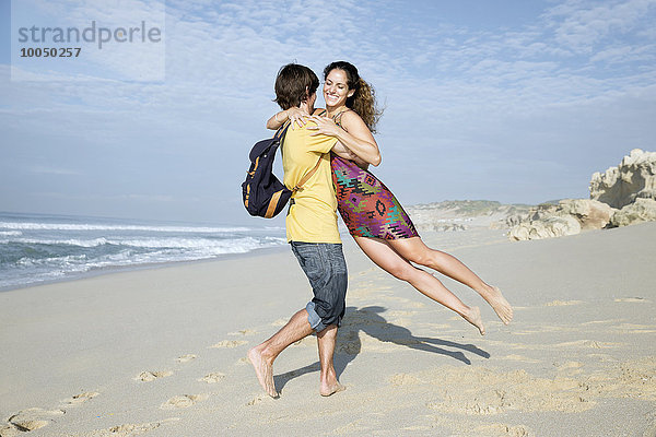 Südafrika  Mann hebt Freundin am Strand hoch