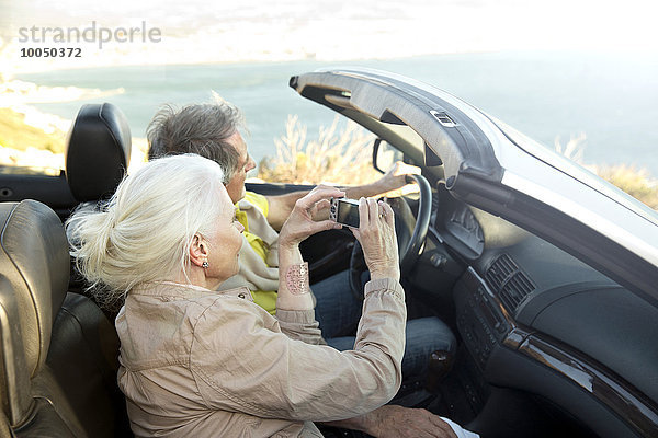 Südafrika  Seniorenpaar in einem Cabrio sitzend mit Blick auf die Aussicht