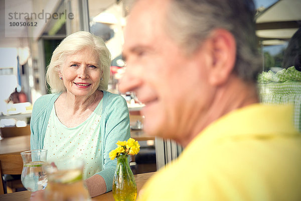 Porträt einer glücklichen älteren Frau  die mit ihrem Mann in einem Café sitzt.