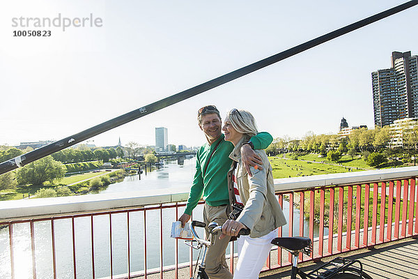 Deutschland  Mannheim  Altes Ehepaar überquert Brücke  Schiebefahrrad