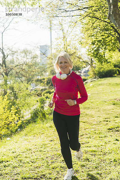 Deutschland  Mannheim  Reife Frau beim Joggen im Park