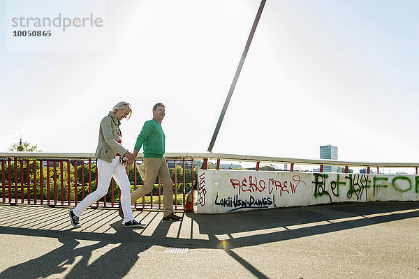 Deutschland  Mannheim  Ehepaar überquert Brücke  Händchen haltend