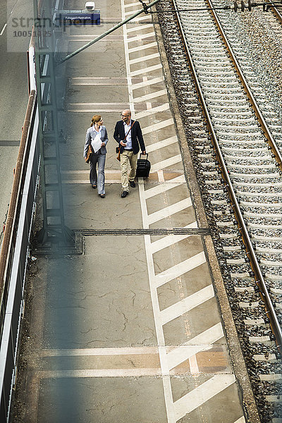 Geschäftsmann und Geschäftsfrau  die auf dem Bahnsteig laufen