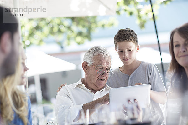 Großvater und Enkel mit digitalem Laptop im Restaurant