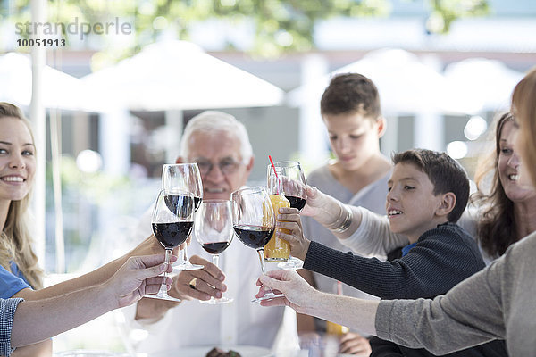 Großfamilie trinkt Rotwein im Restaurant