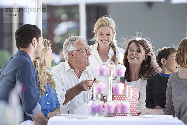 Drei Generationen Familie feiert Großvaters Geburtstag im Restaurant