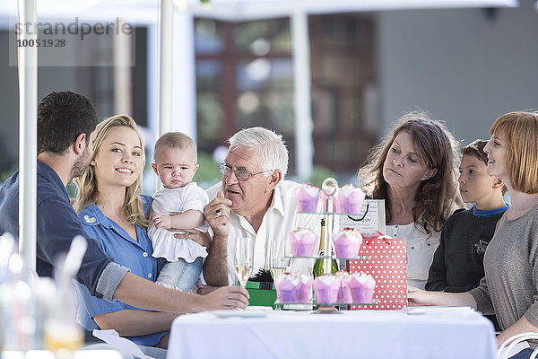 Drei Generationen Familie feiert Großvaters Geburtstag im Restaurant