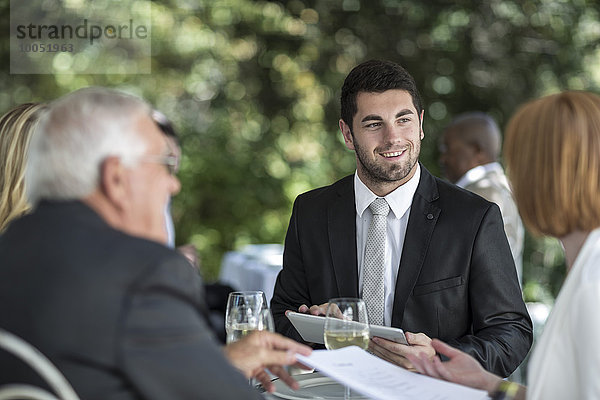 Elegante Leute im Außenrestaurant bei einem Gespräch