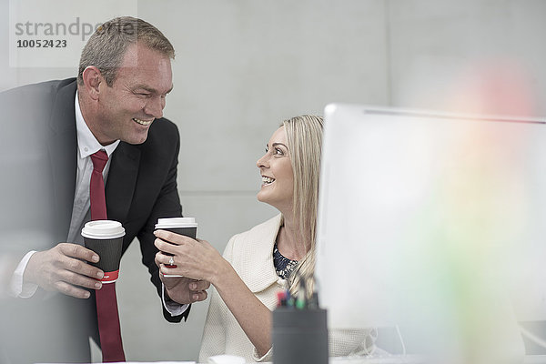 Geschäftsmann und Geschäftsfrau beim Kaffeetrinken im Büro