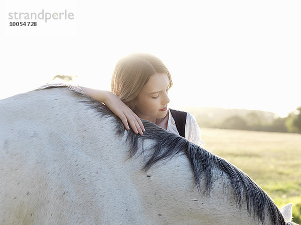 Porträt eines jungen Mädchens mit grauem Pferd