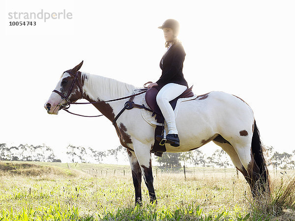 Porträt eines jungen Mädchens beim Reiten auf dem Feld