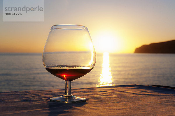 Sonnenuntergang über dem Meer mit Schnapsglas auf dem Tisch  Mallorca  Spanien