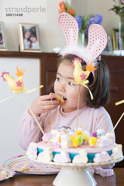 Junges Mädchen mit Hasenohren  Kuchen essen