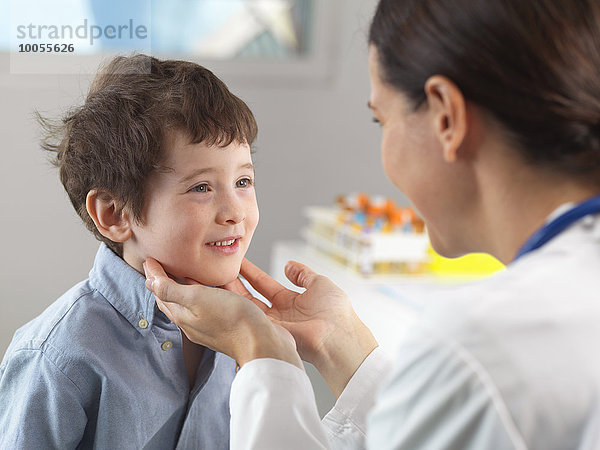 Arzt untersucht Drüsen des kleinen Jungen in der Klinik