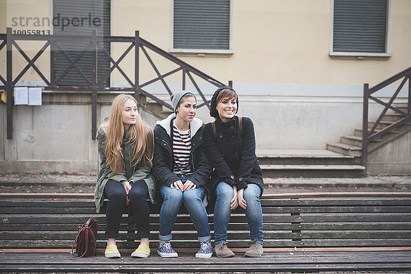 Drei Schwestern sitzen auf der Parkbank