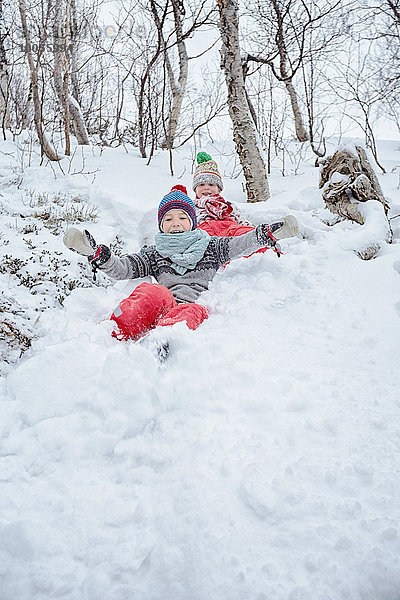 Zwei Brüder rutschen den schneebedeckten Hügel hinunter  Hemavan  Schweden