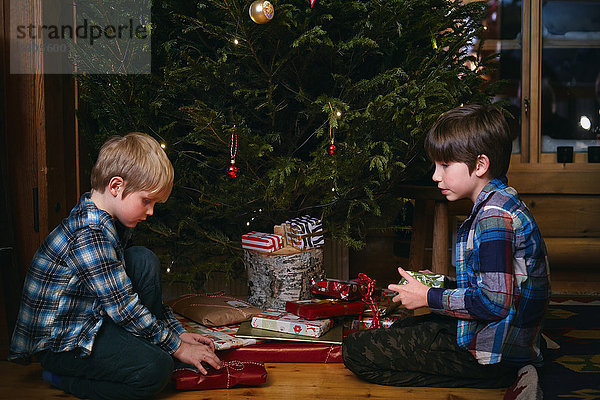 Zwei Brüder eröffnen Weihnachtsgeschenke