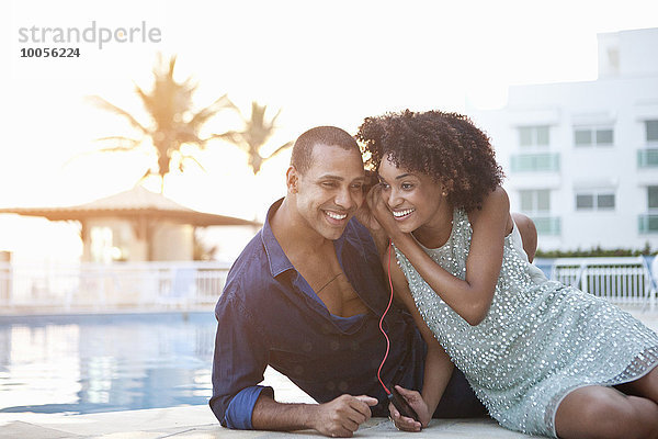 Stilvolles Paar mit gemeinsamen Kopfhörern am Pool  Rio De Janeiro  Brasilien