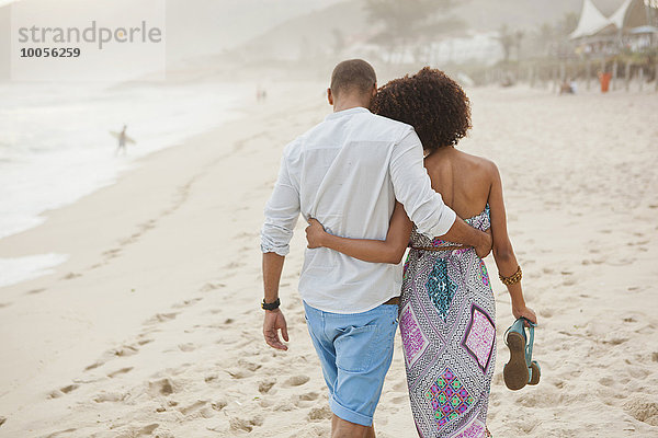 Rückansicht des Paares  das am Strand spazieren geht  Rio De Janeiro  Brasilien