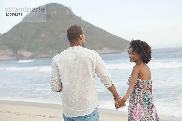 Paar  das Hand in Hand am Strand spazieren geht  Rio De Janeiro  Brasilien