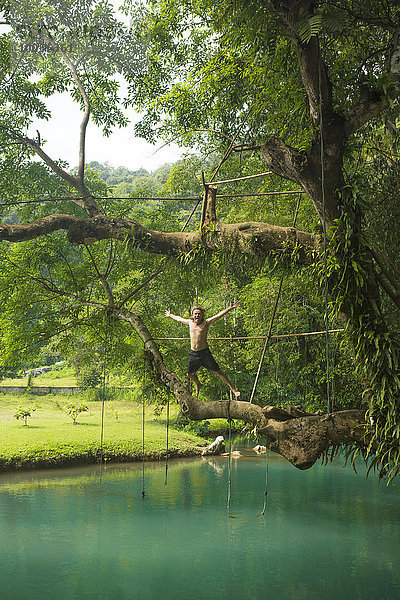 Reifer Mann springt in die türkisfarbene Lagune  Vang Vieng  Laos