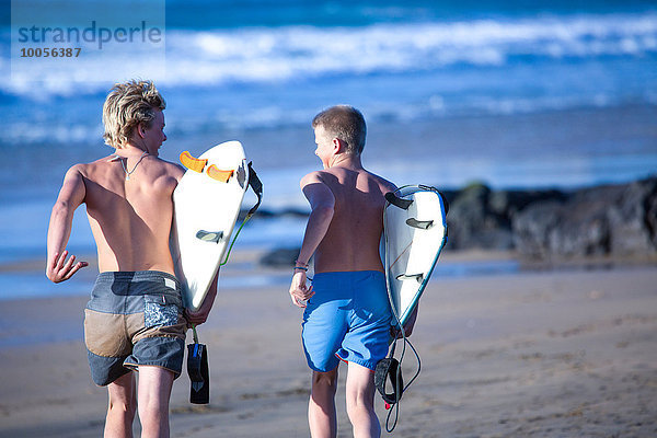 Zwei männliche Teenager-Surfer auf dem Weg zum Meer  Fuerteventura  Spanien