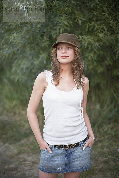 Porträt einer jungen Frau mit Mütze und Händen in den Taschen