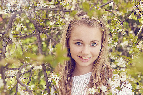 Porträt des hübschen Mädchens und der Baumblüte