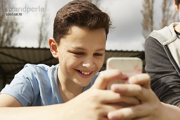 Lächelnder Junge liest Smartphone-Textnachricht