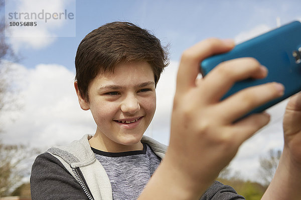 Lächelnder Teenager nimmt Smartphone Selfie