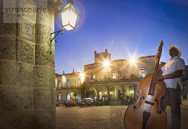 Senior Mann spielt Kontrabass auf der Plaza de la Cathedral bei Nacht  Havanna  Kuba