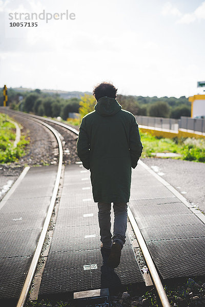 Rückansicht eines erwachsenen Mannes auf dem Bahnübergang