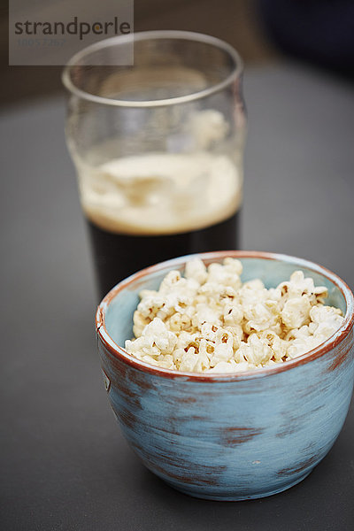 Schale mit Popcorn und einem Glas Bier
