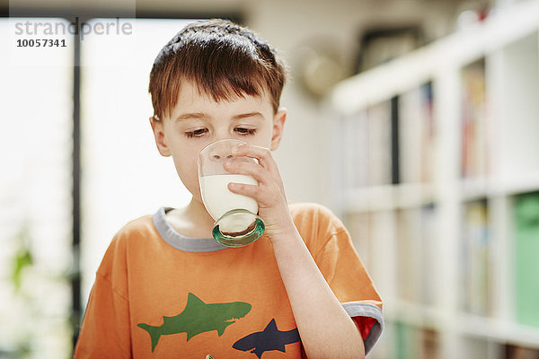 Kleiner Junge trinkt ein Glas Milch.