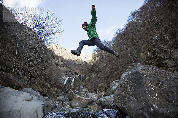 Mann springt über den Fluss Toce  Premosello  Verbania  Piemont  Italien