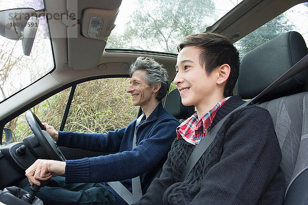 Erwachsener Mann und jugendlicher Sohn beim Autofahren