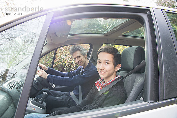 Porträt eines reifen Mannes und eines jugendlichen Sohnes beim Autofahren