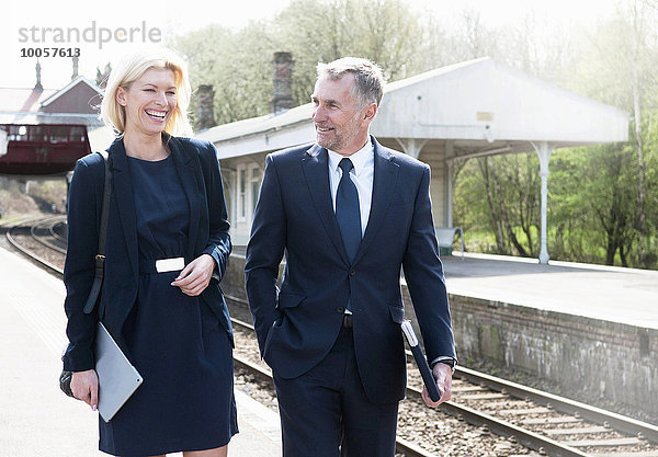 Geschäftsmann und Frau im Gespräch auf dem Bahnsteig